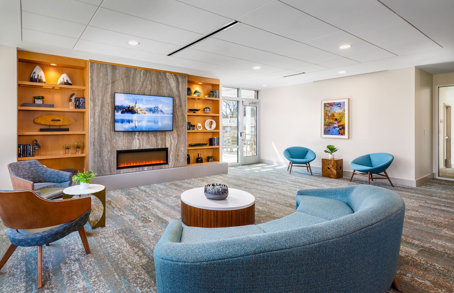 A living room with a couch , chairs , table and television.