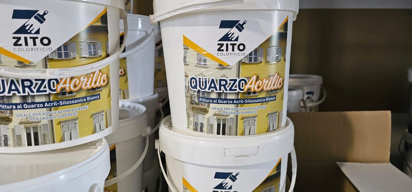 Secchi di vernice Zito Cuarzo Acrilico impilati su uno scaffale.