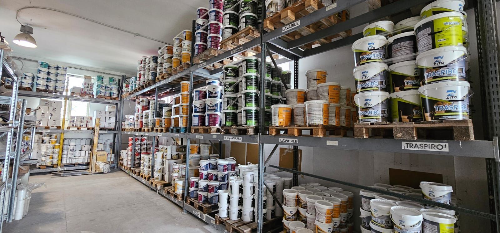 Scaffali pieni di barattoli di vernice in un magazzino.