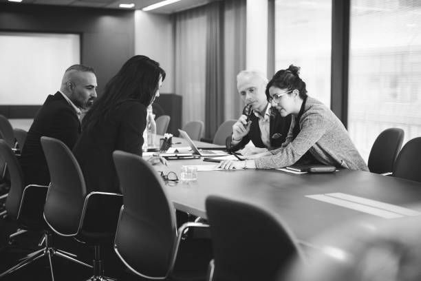 A group of people are sitting around a conference table in a conference room.