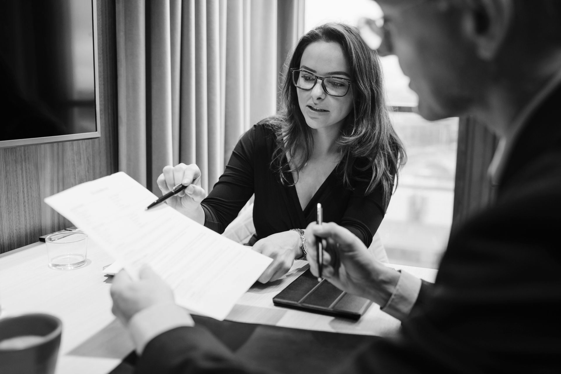 A man and a woman are sitting at a table looking at a piece of paper.