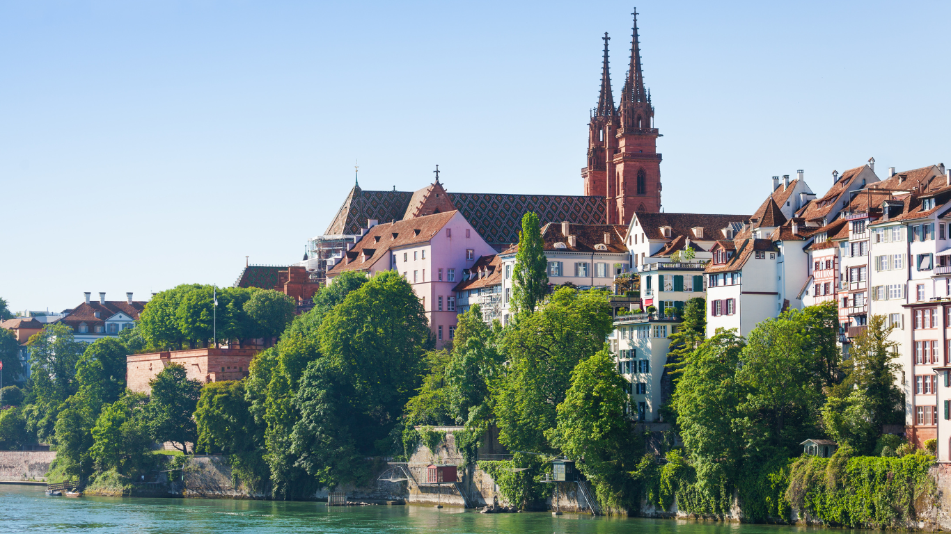 Eine Stadt mit einer großen Kathedrale im Hintergrund und einem Fluss im Vordergrund.