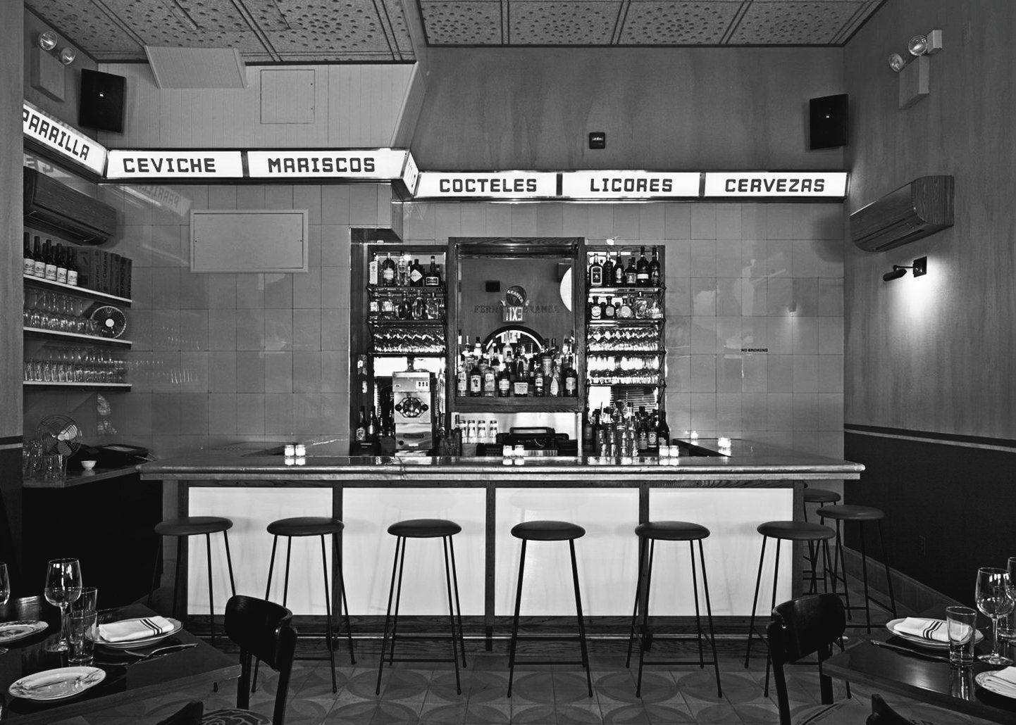 Black and white photo os a bar, with signage at the top reading 