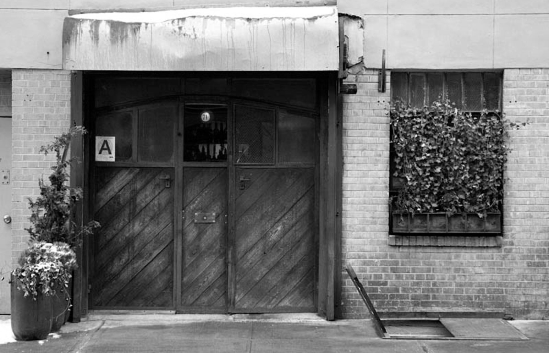 Black and white photo of the door at the restaurant Holy Ground.