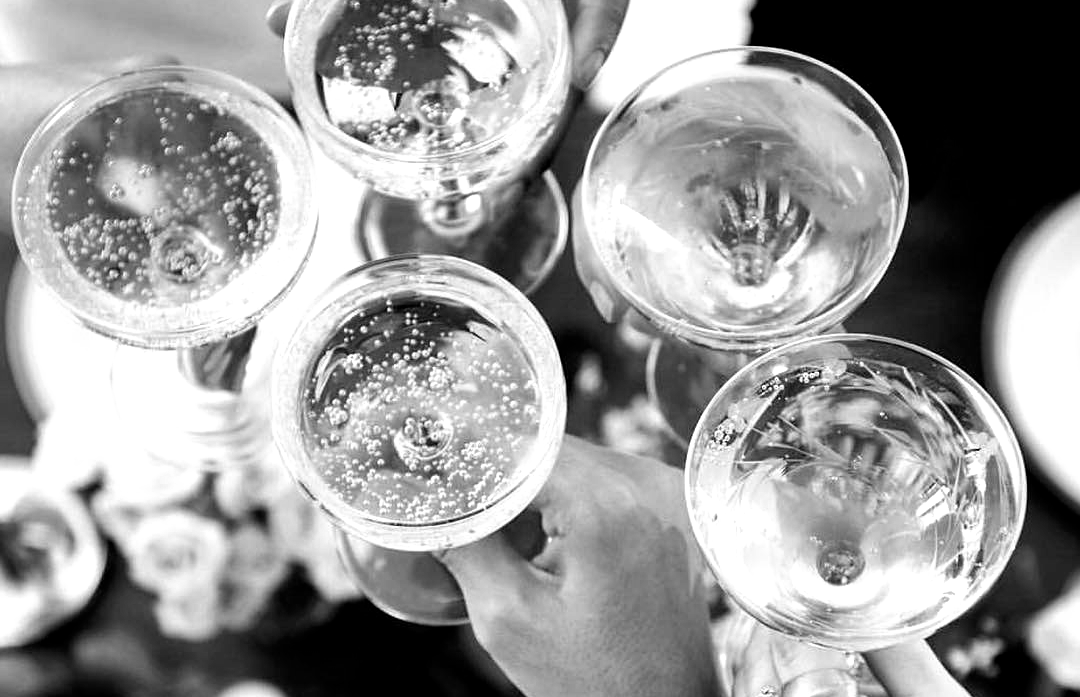 Black and white photo of 5 glasses os sparkling wine