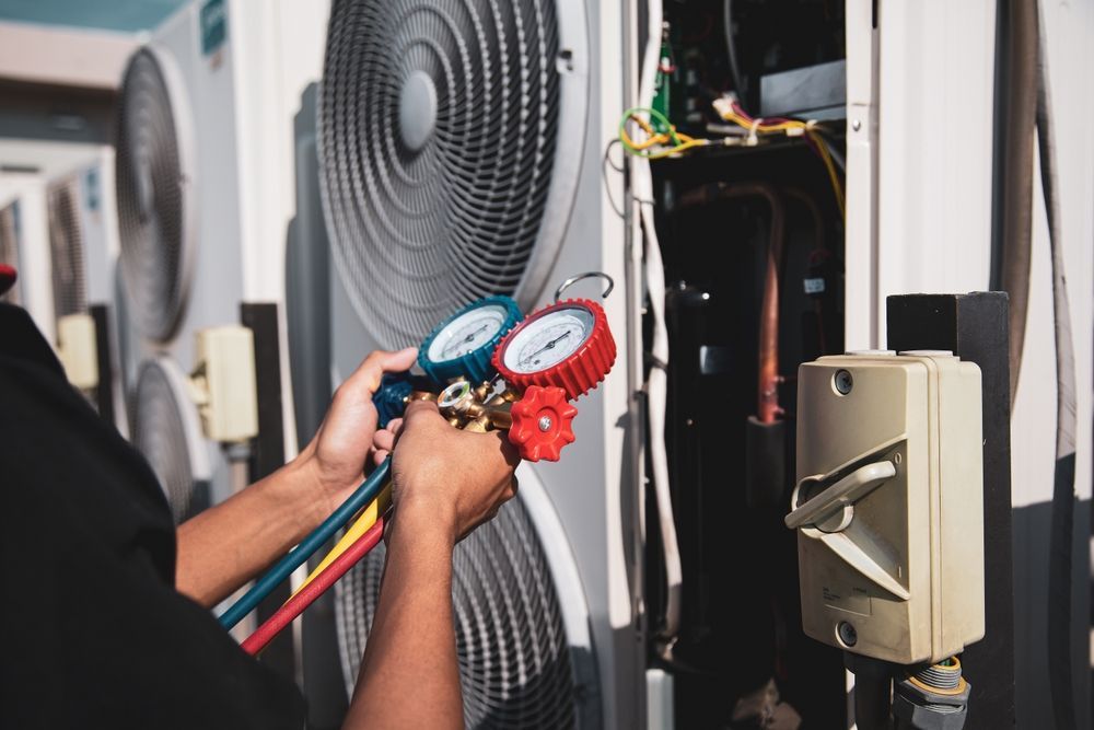 Technician checking HVAC refrigerant gauges on an outdoor air conditioning unit