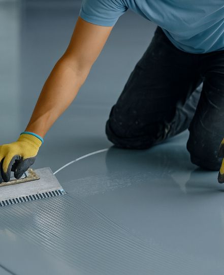 worker applying epoxy flooring
