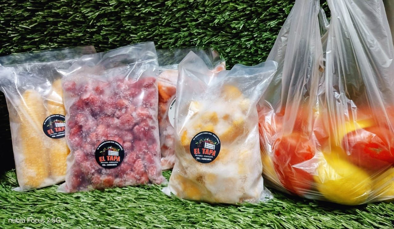 Una persona sostiene tres bolsas de basura negras en sus manos.