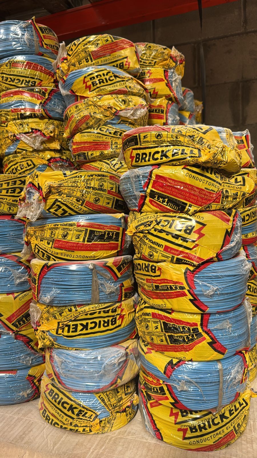 Un grupo de rollos de envoltura de plástico se apilan uno encima del otro sobre un fondo blanco.