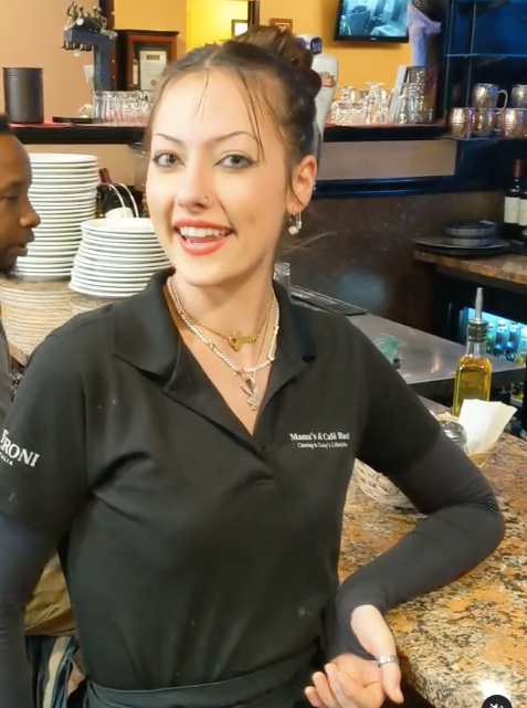 A woman wearing a black shirt serving at Mama’s Cafe Baci