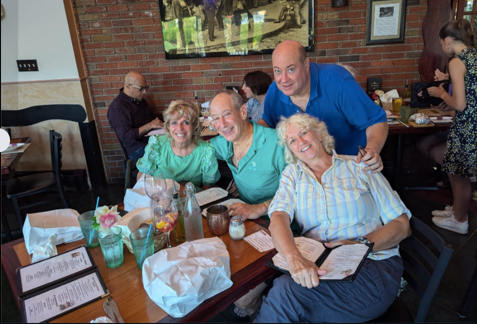 A group of people are posing for a picture at a table at Mama's restaurant.