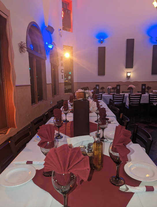 A long table in a restaurant with red napkins and wine glasses at Mama’s Cafe Baci