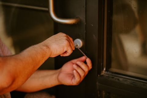 Business Lockout — Woman Opening Door with Key in Bellevue, NE