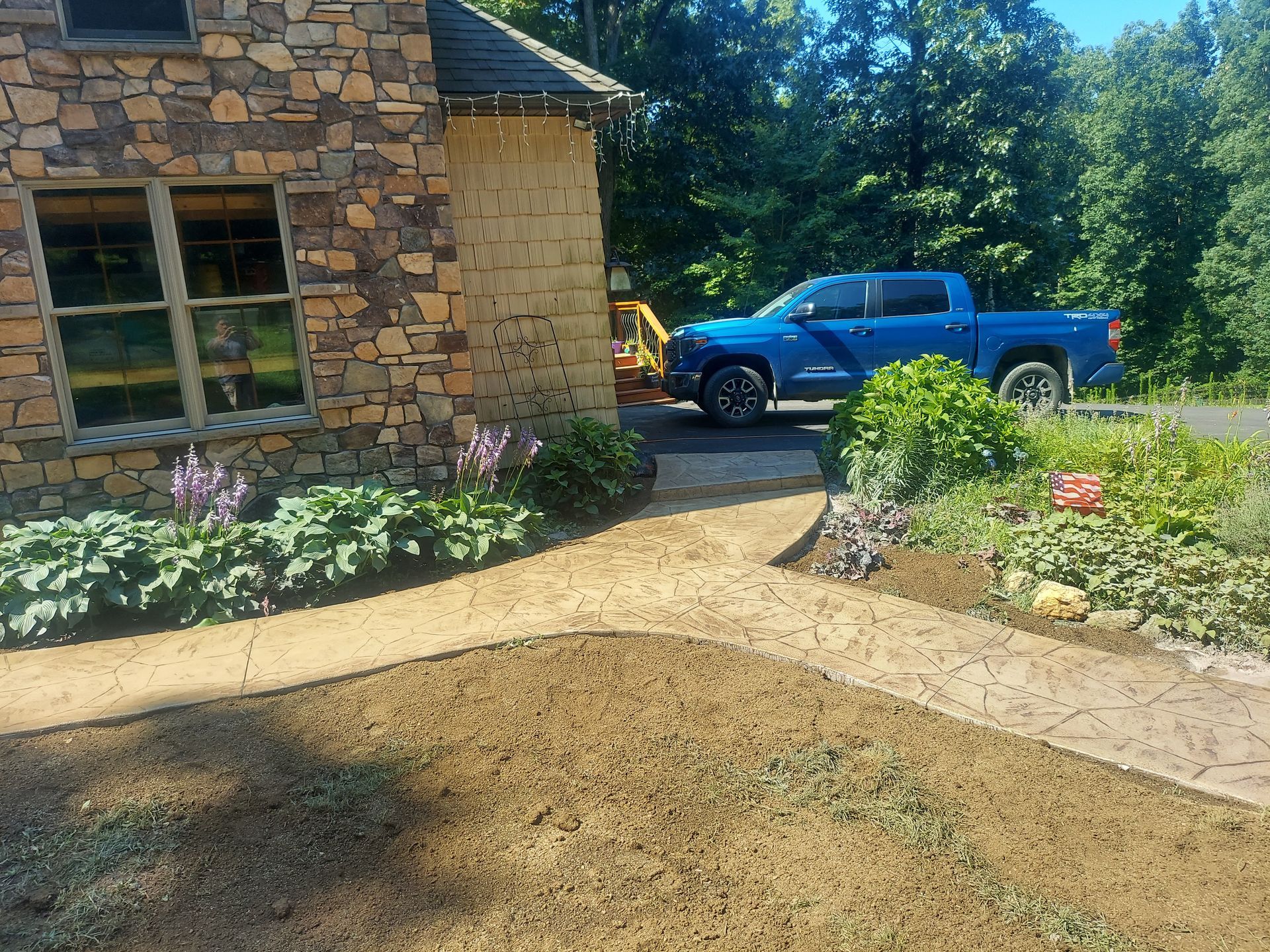 A blue truck is parked in front of a stone house.