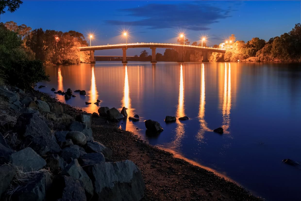 A Bridge Over A Body Of Water At Night — Furniture & Auto Pride in Taree, NSW