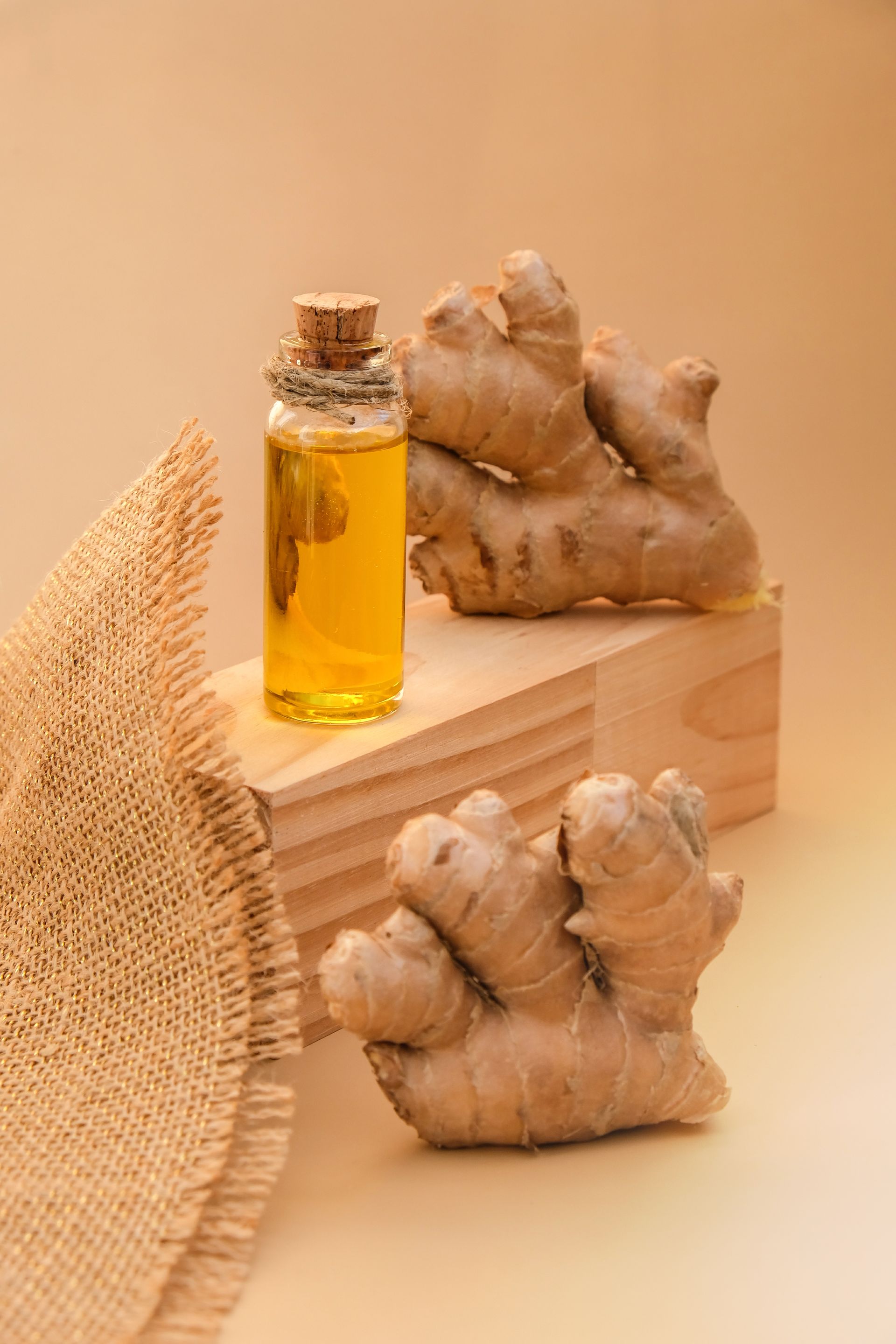 Il y a une bouteille d'huile essentielle à côté des racines de gingembre.