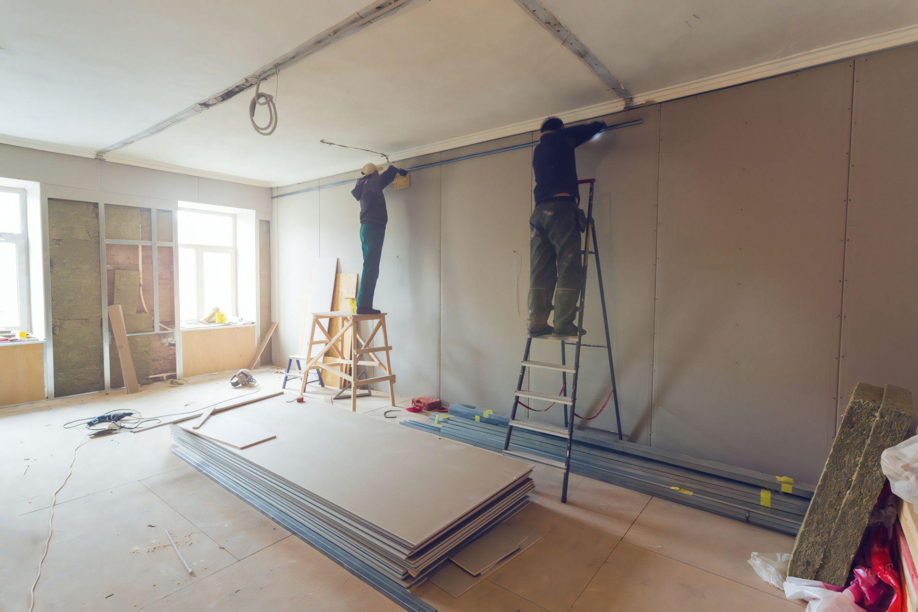 Workers Installing Plasterboard In Apartment — Cemak Constructions in Port Macquarie, NSW