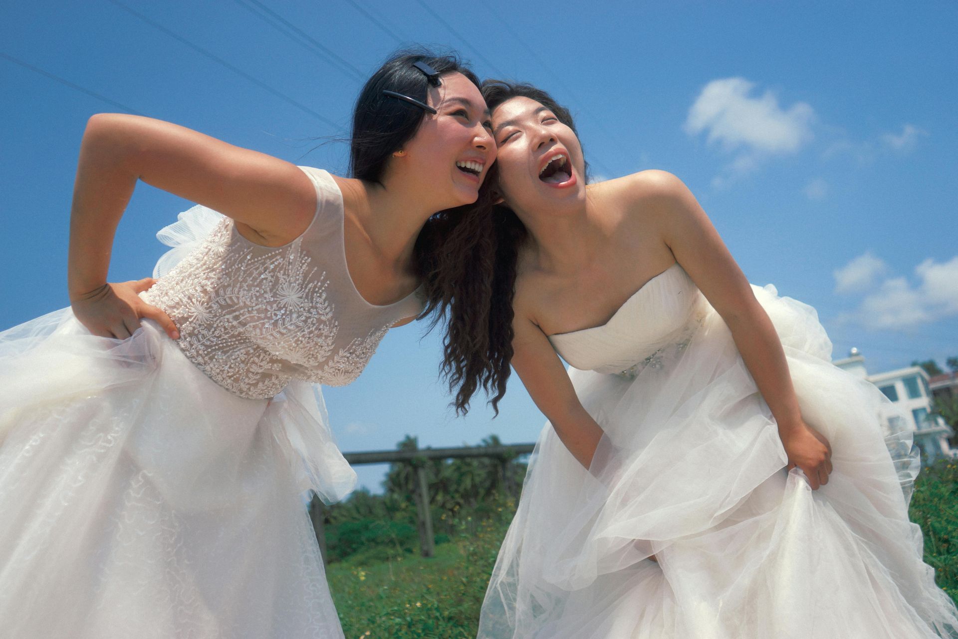 Three women in wedding dresses are sitting on a couch.