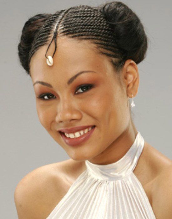 A woman in a white dress with braids on her head