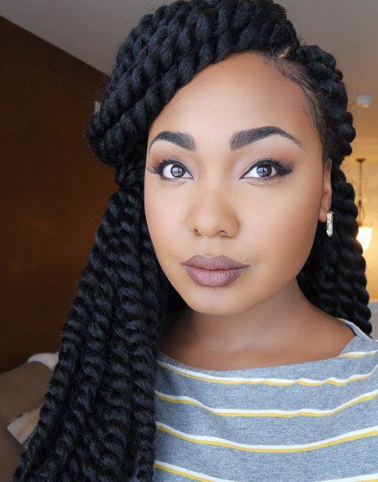 A woman with braids is wearing a striped shirt