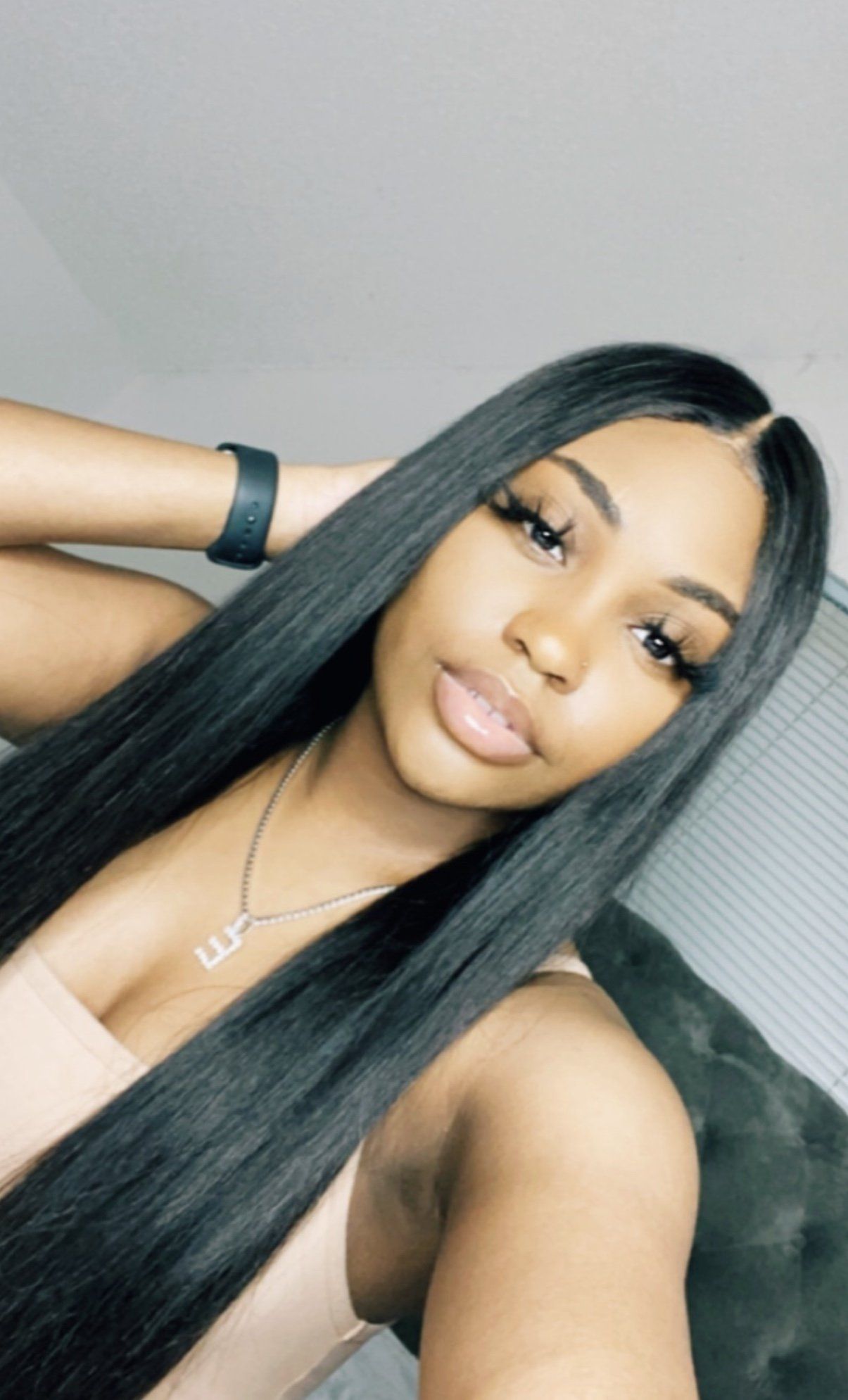 A woman with long black hair is taking a selfie.