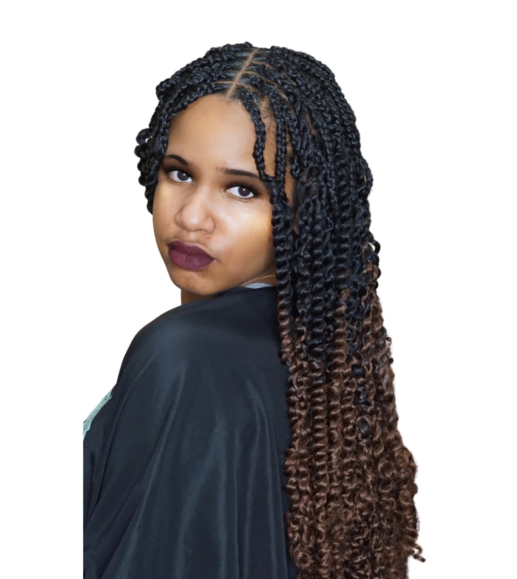 A woman with braids is wearing a black cape