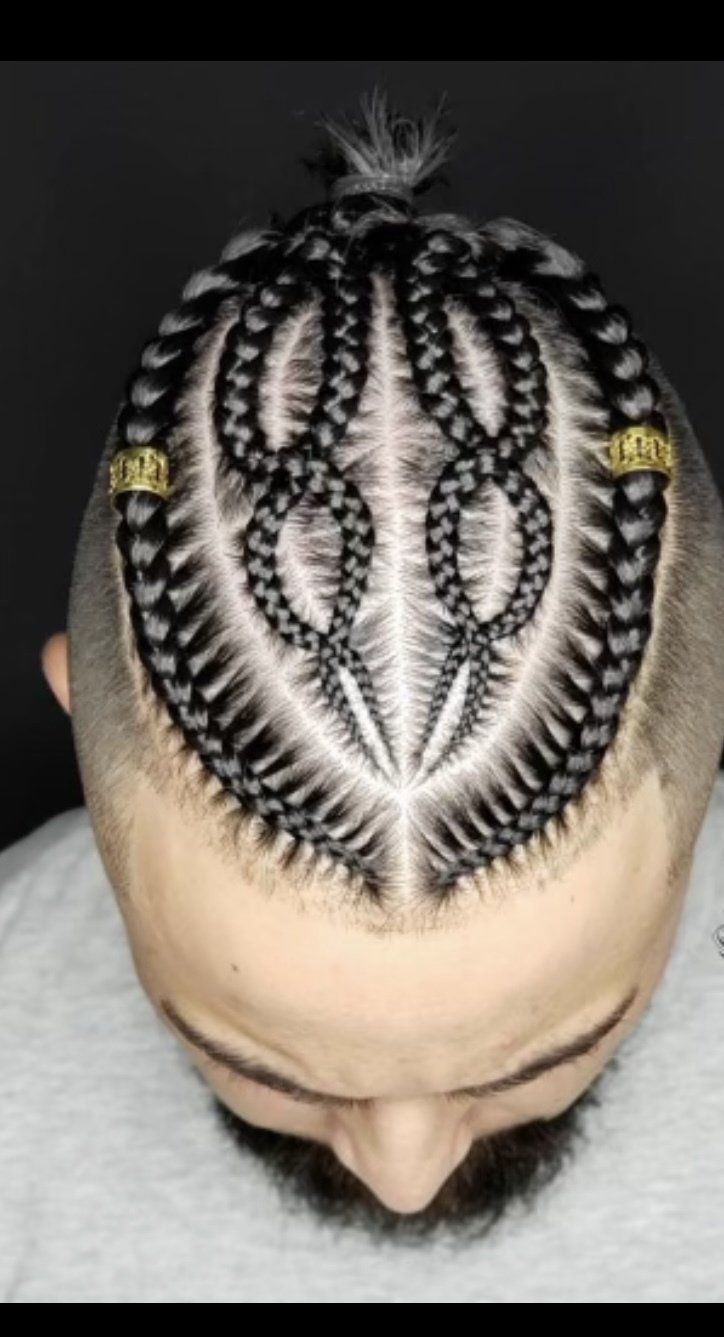 A man with braids in his hair is wearing a white shirt.
