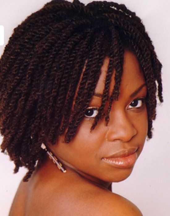 A woman with braided hair looks over her shoulder at the camera