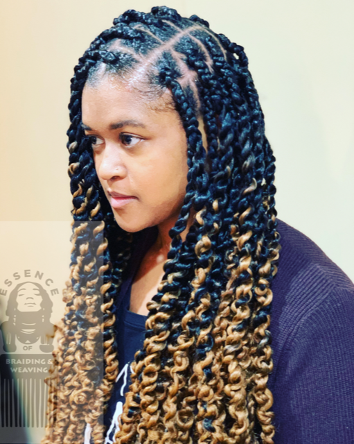 A woman with long braids is wearing a black shirt