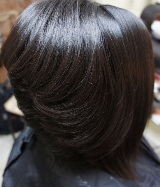 A close up of a woman 's hair with a black cape