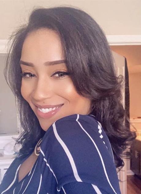 A woman in a blue and white striped shirt is smiling