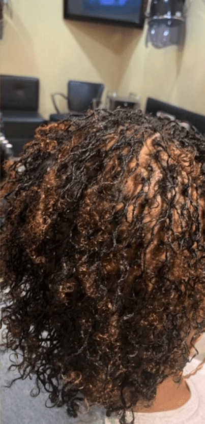 A woman with curly hair is sitting in a waiting room.