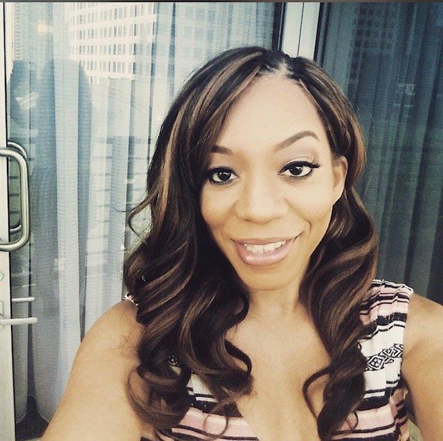 A woman in a striped top smiles for the camera