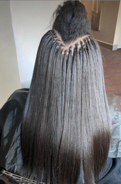A woman is sitting in a chair with her hair in a bun.
