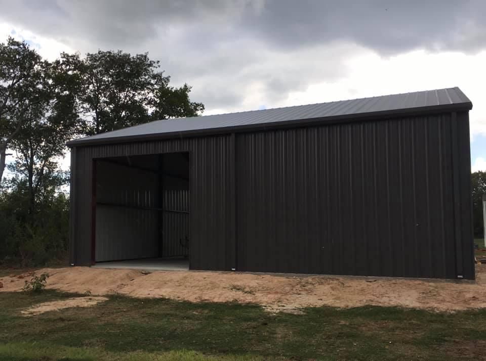 Dark brown metal shed with an open entrance on a cloudy day.