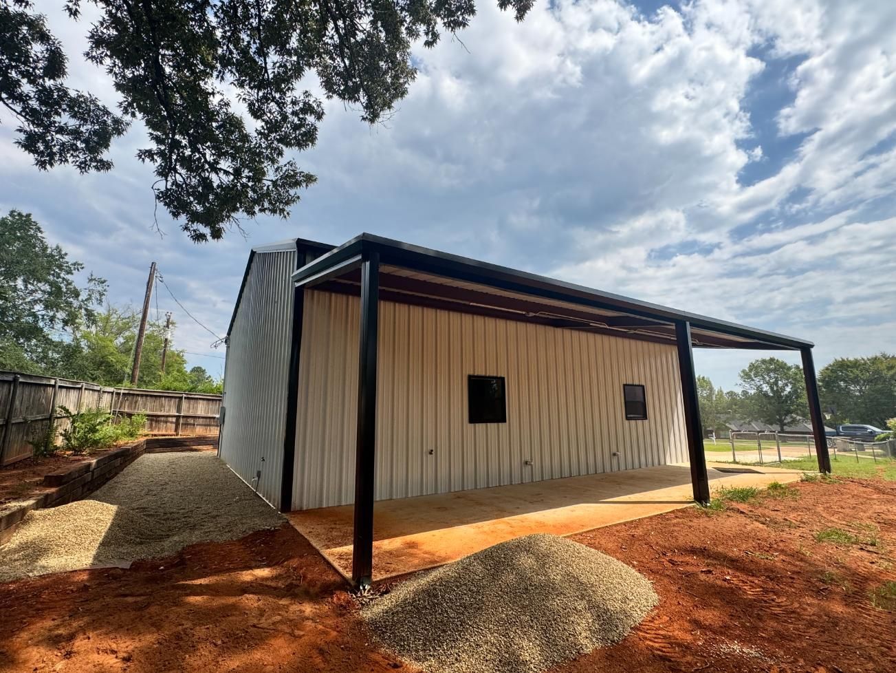 Modern building with black trim, wooden siding, and an awning on a cloudy day.