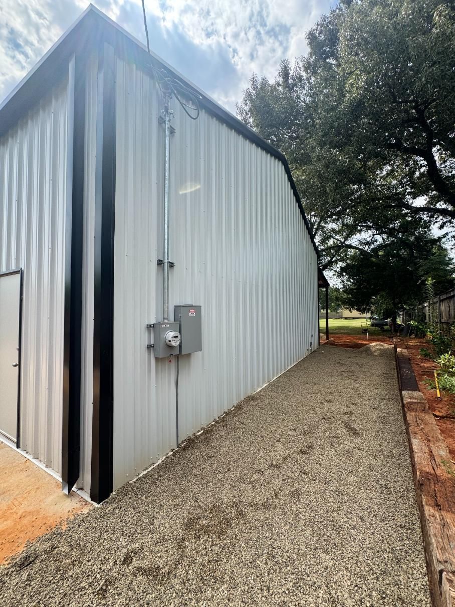 Metal building with gravel path and electrical box. Black accents.