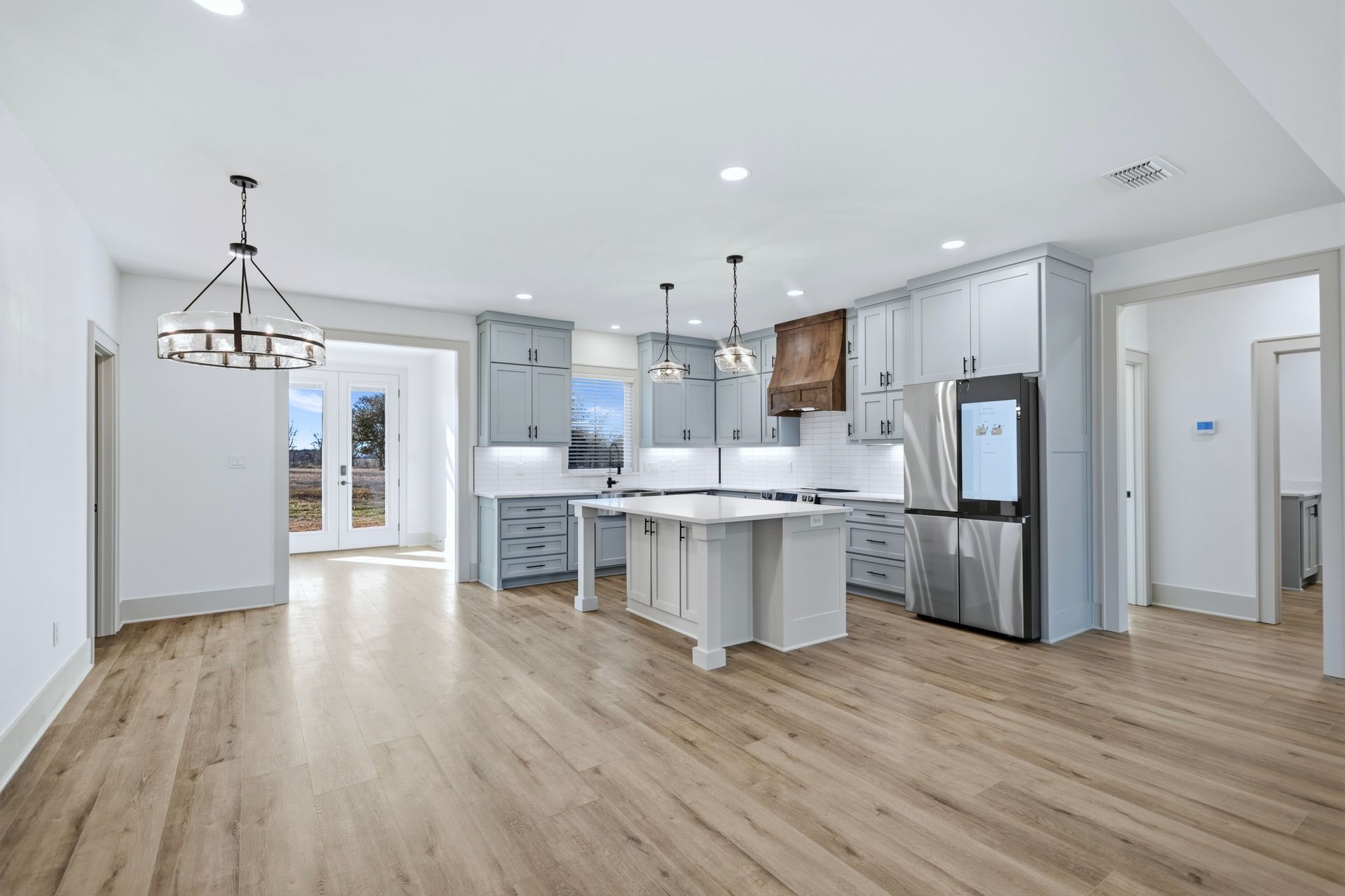 Spacious white bathroom with double vanity, black fixtures, large mirrors, and a walk-in closet.