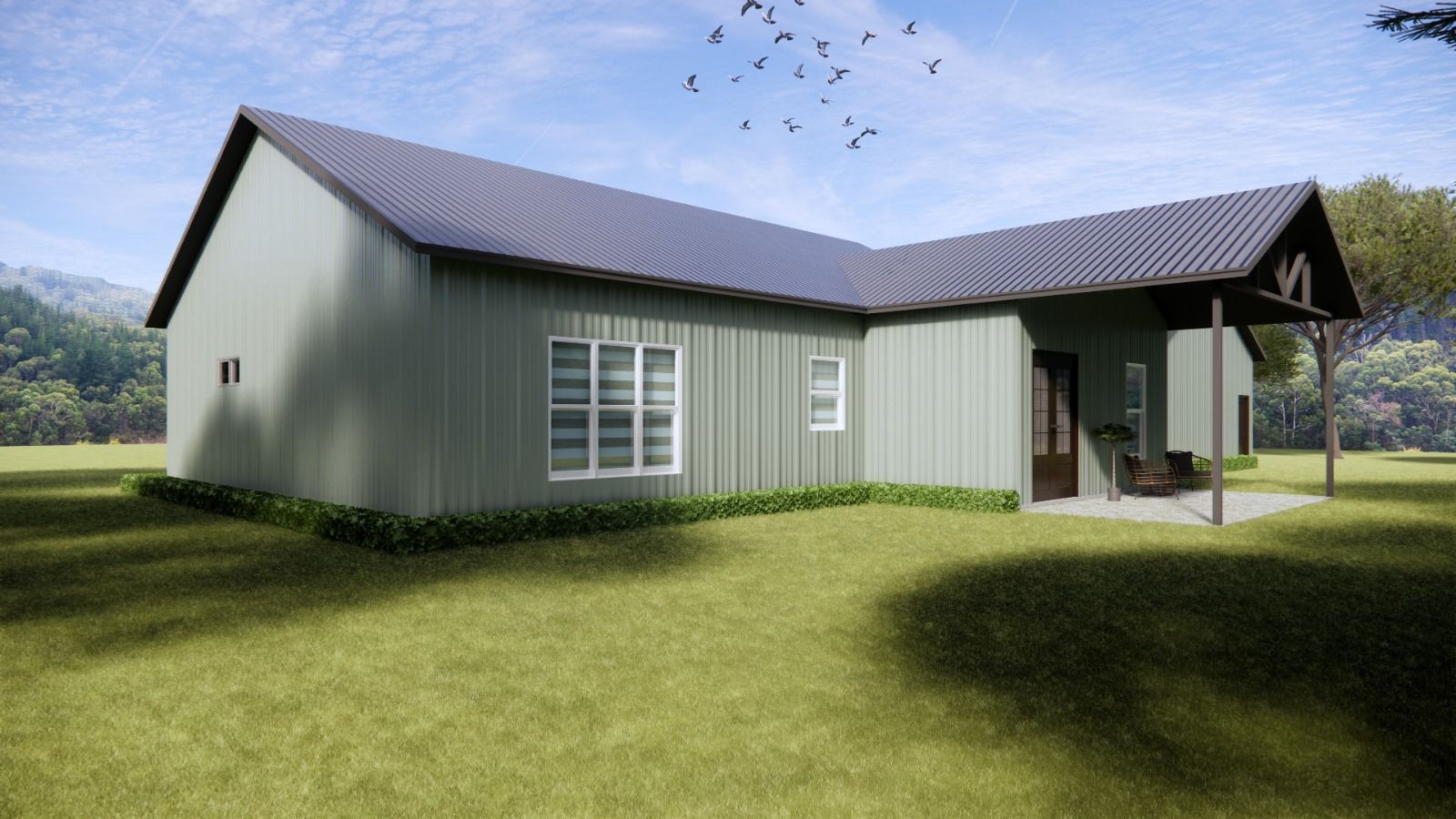 Green metal-sided house with black roof and porch, set in a grassy field with trees and blue sky.