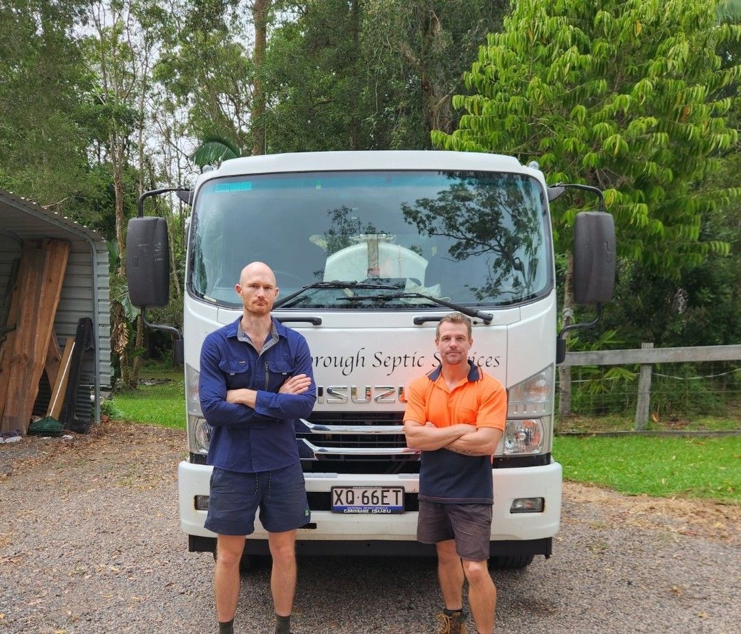 Two men stand in front of a white septic service truck, arms crossed. Outdoors, trees in the background  — Landsborough Septic Services in Landsborough, QLD