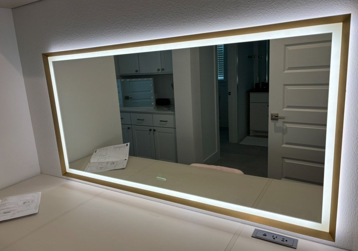 A large mirror is hanging on a wall in a room.