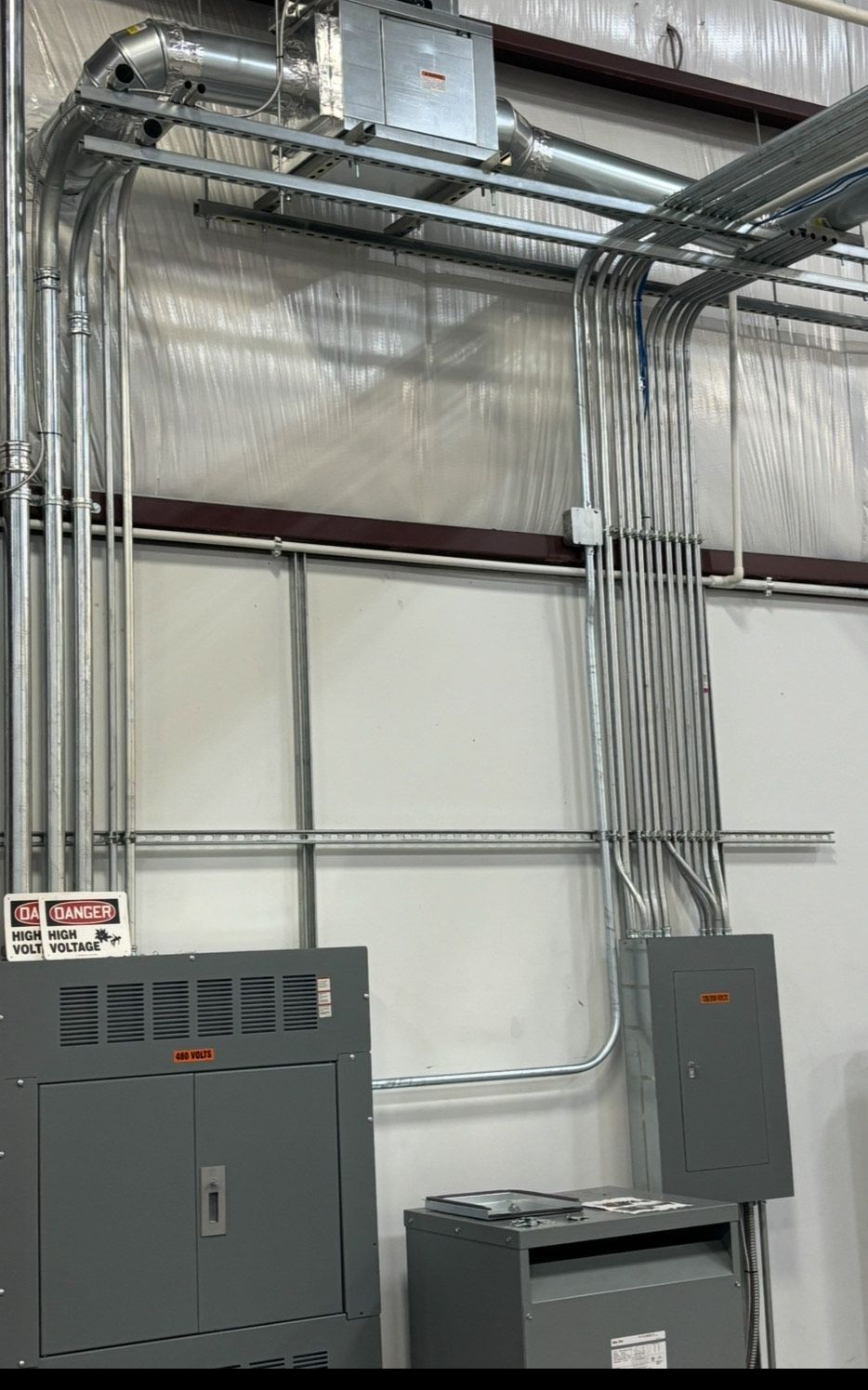 A room with a lot of electrical wires hanging from the ceiling.