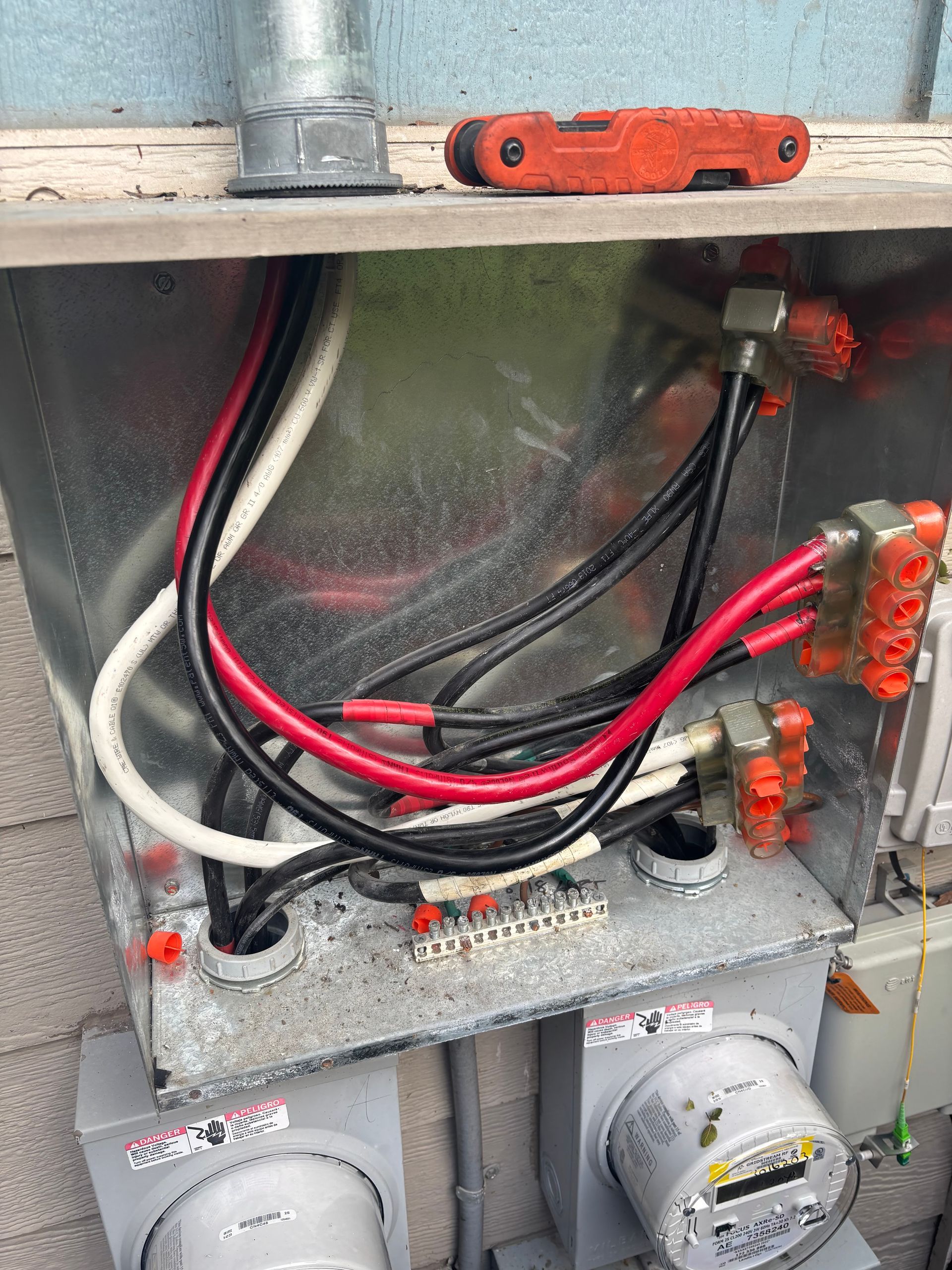 A close up of a electrical box with a lot of wires coming out of it.