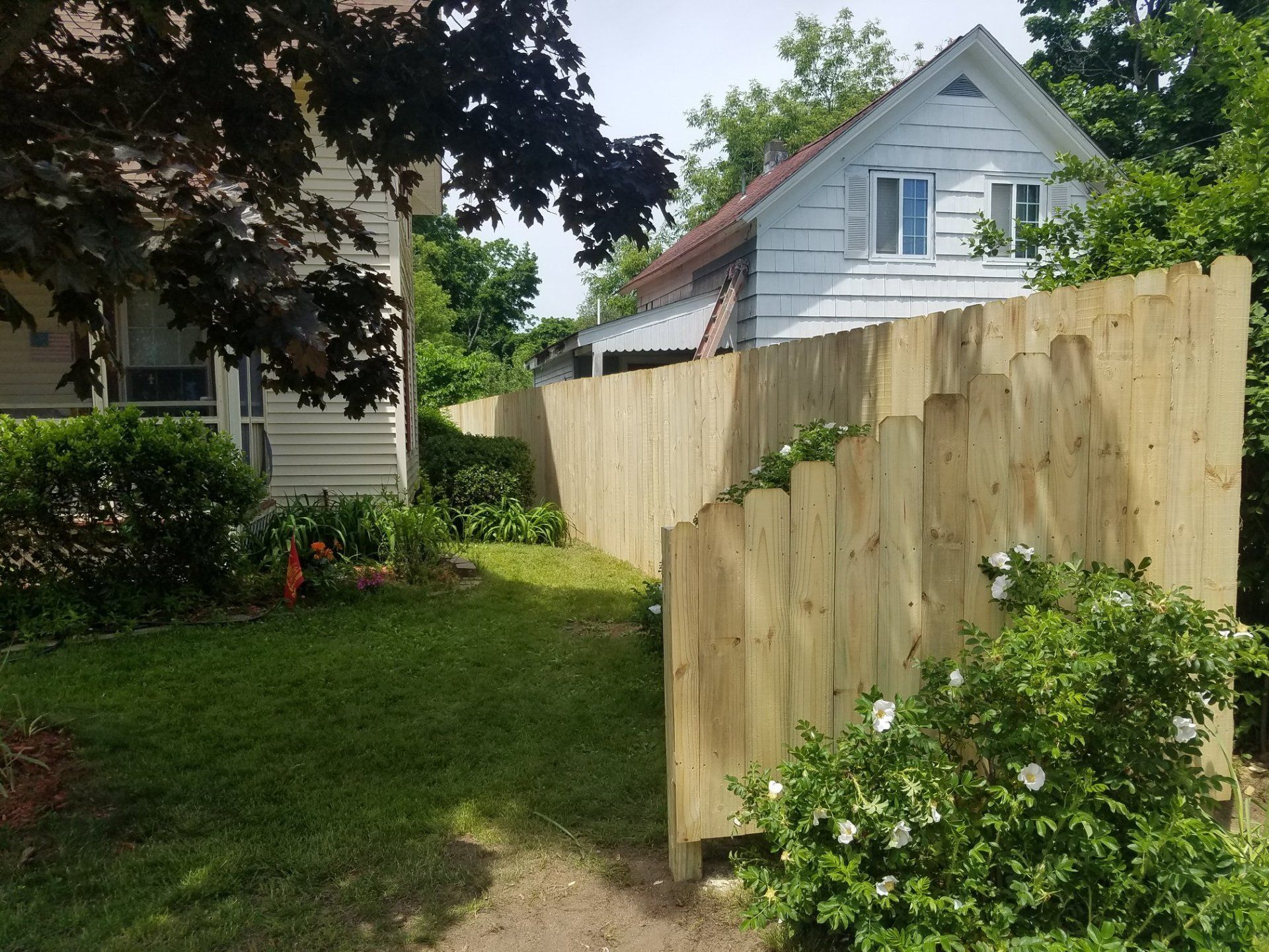 Flowers in front of beautiful wooden fence installed in Concord, New Hampshire