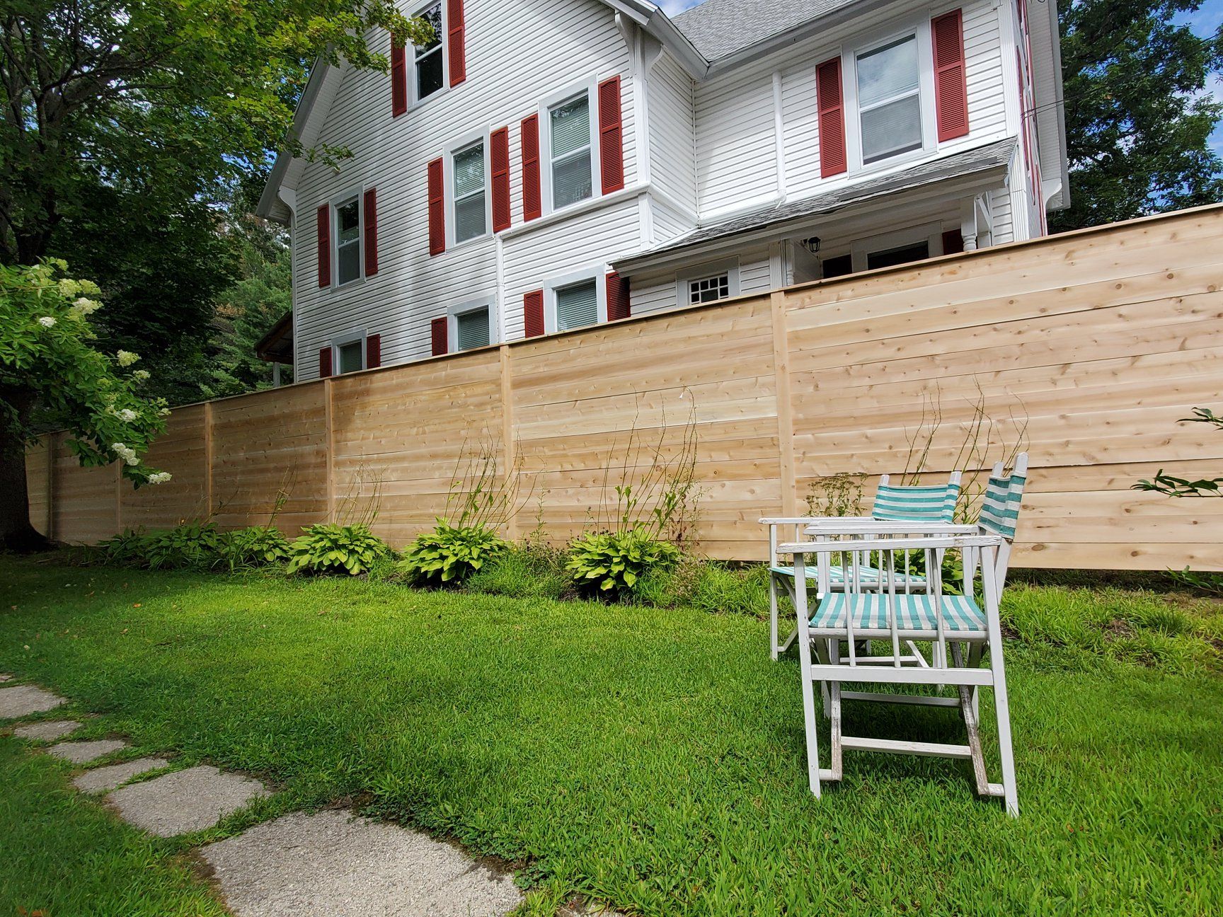Two lawn chairs in front of a newly installed fence