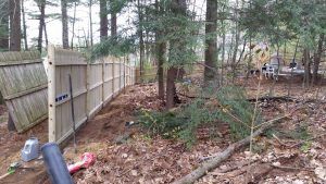 Old fence falling down being replaced with a new fence