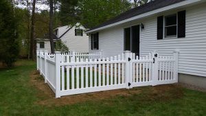 White picket fence with a home in the background