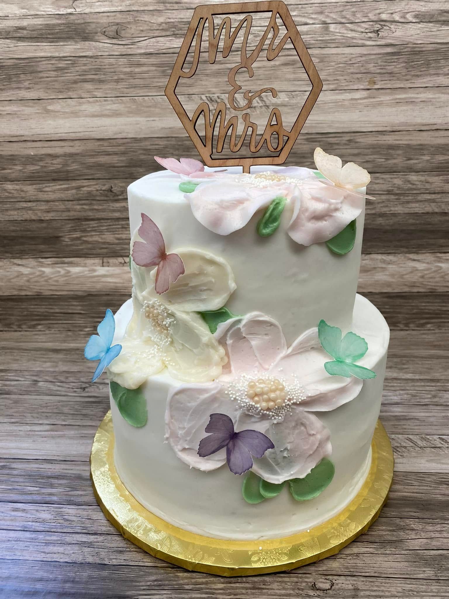 wedding cake with pastel butterflies and flowers