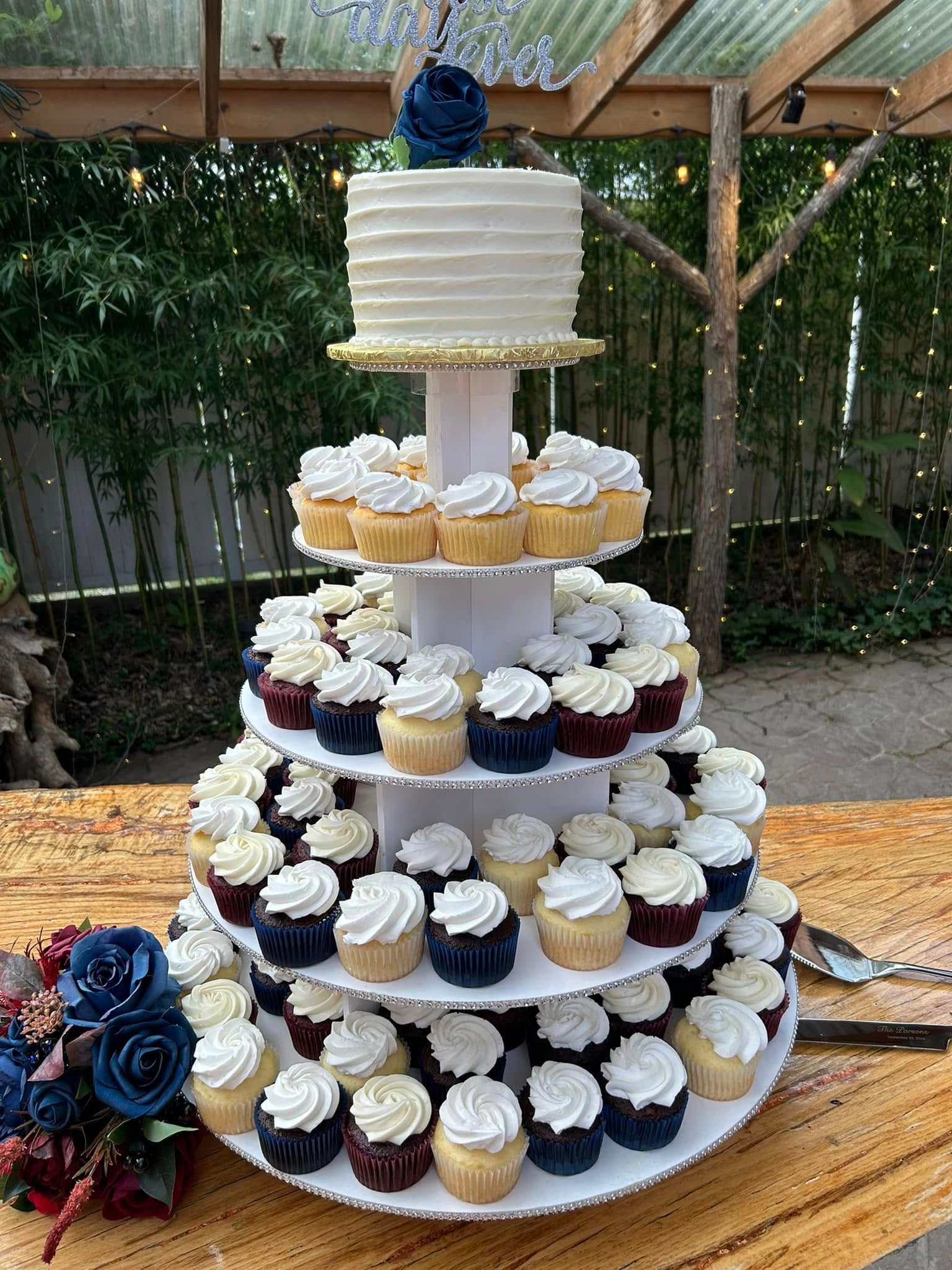 tiered wedding cake and cupcakes