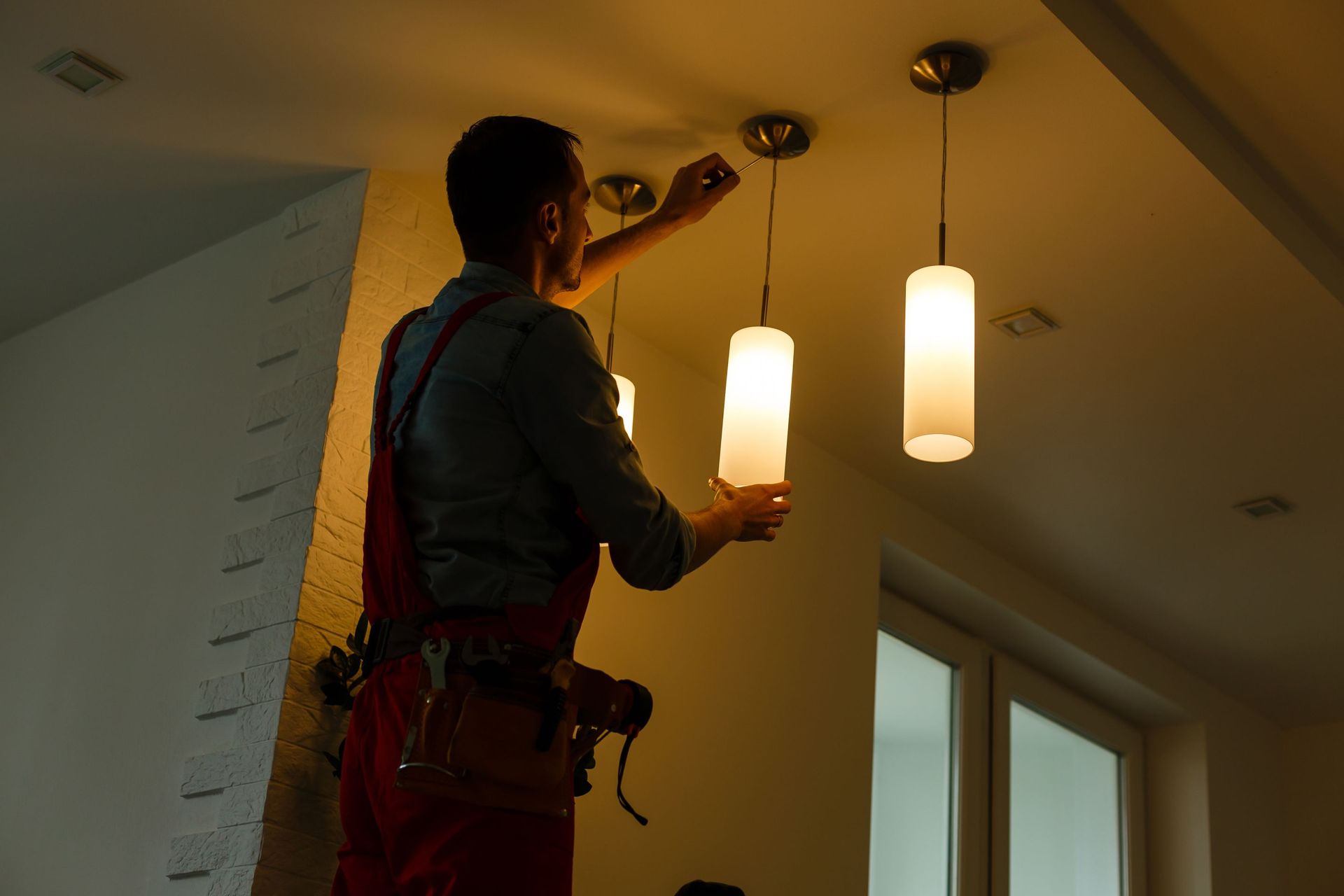 electrician installing connecting lamp ceiling